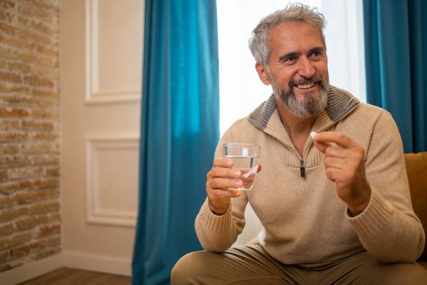 Uomo di mezza età consuma probiotici con Augumentin per mitigare gli effetti collaterali