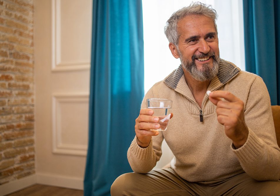 Uomo di mezza età consuma probiotici con Augumentin per mitigare gli effetti collaterali