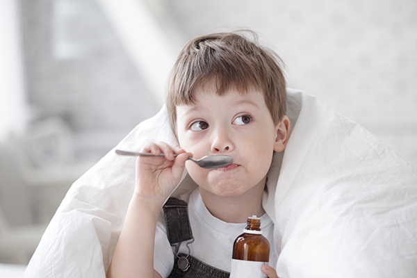 Bambino piccolo che consuma rimedio naturale per il mal di gola