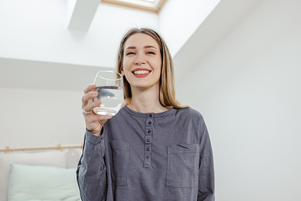 Donna beve molta acqua come rimedio naturale contro la cistite
