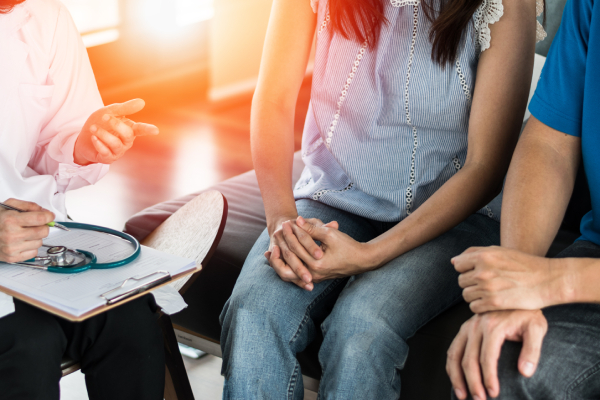 Giovane coppia parla con medico per prevenzione infezioni