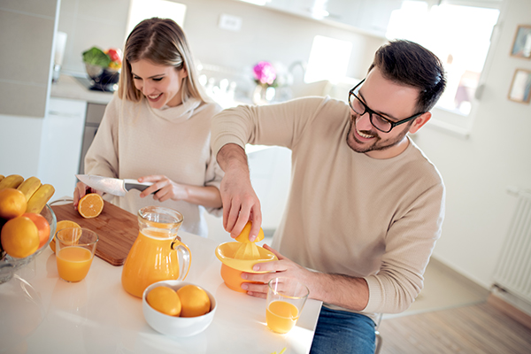 Coppia che produce spremute d’arancia e consuma vitamina C
