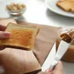 Crema spalmabile al burro di arachidi su fette biscottate
