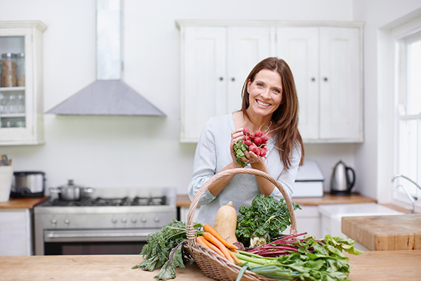 Una donna gode dei benefici dati dall’uso dei ravanelli in cucina e di altre verdure di stagione