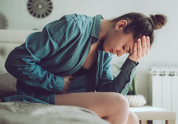 Donna avverte i sintomi della cistite, tra cui fastidio o dolore durante la minzione