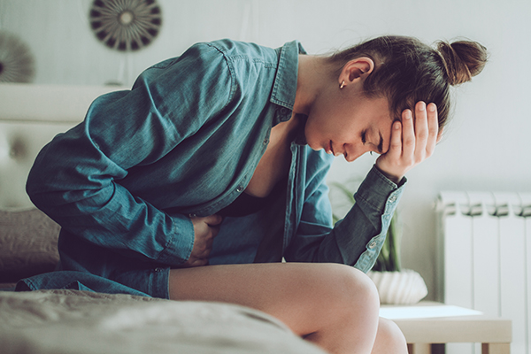 Donna avverte i sintomi della cistite, tra cui fastidio o dolore durante la minzione