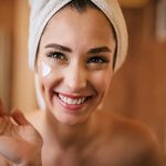 Donna applica la crema giorno sul viso