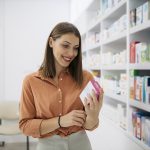 Donna in farmacia che legge informazioni sulla confezione di Augumentin