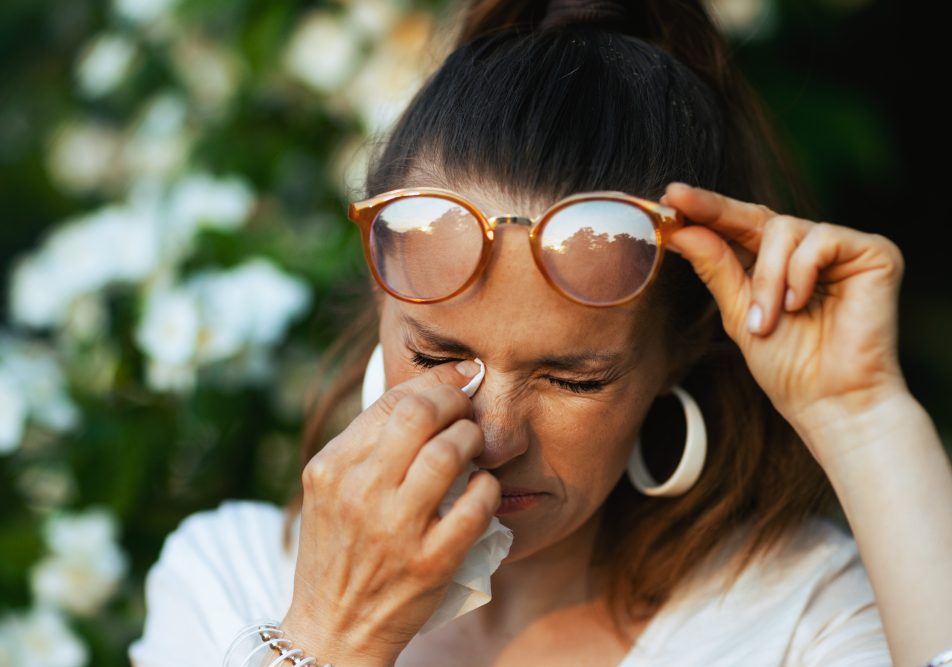 Donna che si strofina l'occhio a causa di allergia primaverile