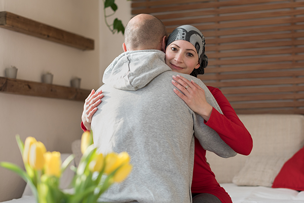 Donna malata di tumore alle ossa abbracciando il suo partner
