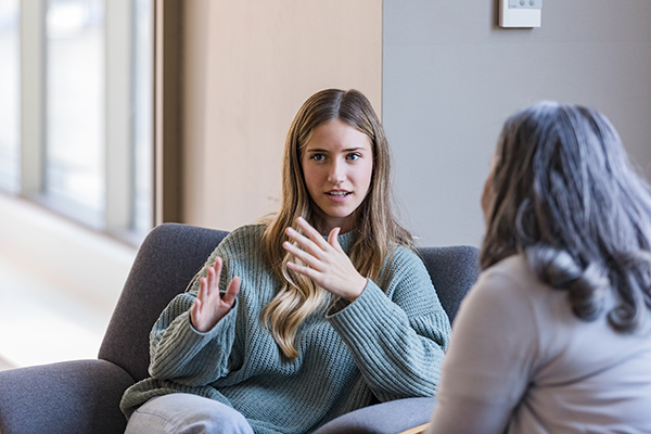 Giovane donna che dialoga apertamente con la psicoterapeuta durante una seduta di psicoterapia