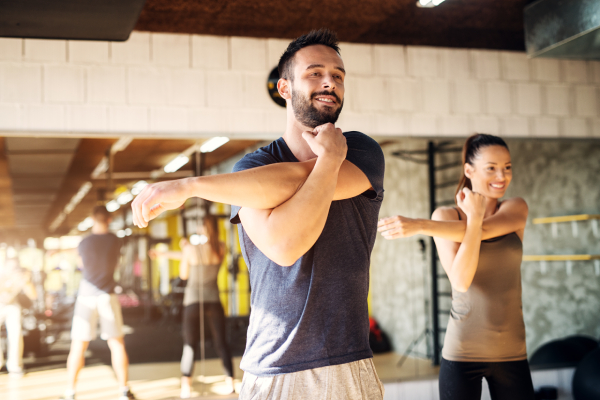 Uomo e donna che svolgono stretching per i tricipiti