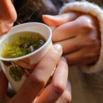 Giovane donna beve tisana per alleviare i sintomi della cistite