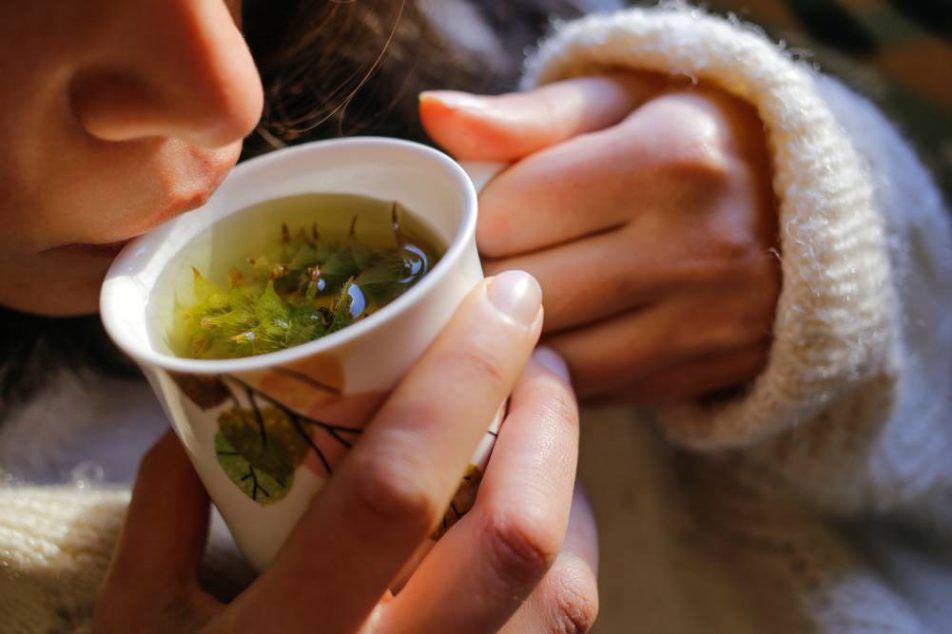tisane-per-infezione-cistite Giovane donna beve tisana per alleviare i sintomi della cistite