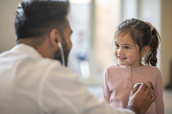 Bambina che soffre di una lieve stomatite alla lingua durante una visita pediatrica