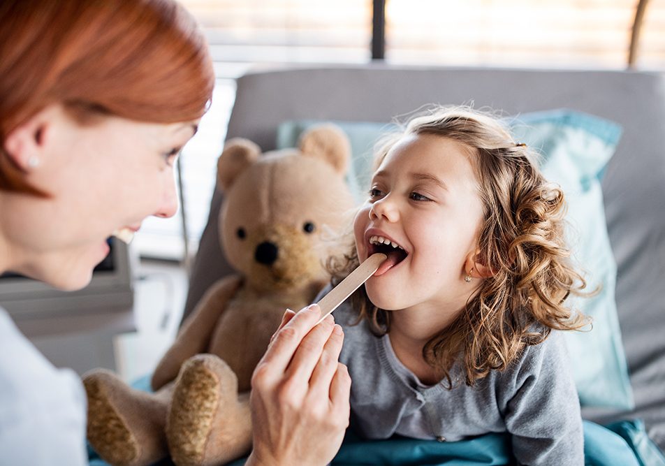 bambina-sottoponendosi-tampone-streptococco Bambina sorridente che si sottopone al tampone per lo streptococco dalla pediatra