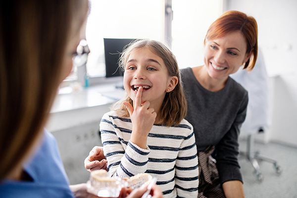 Bambina alla visita odontoiatrica per la cura dei denti da latte, insieme alla sua mamma