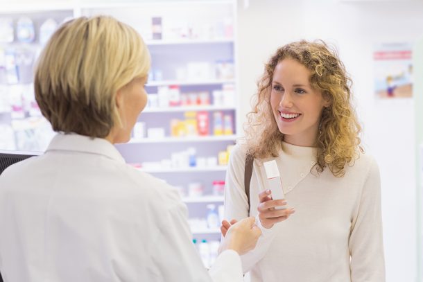 Caregiver che riceve il farmaco al bancone della farmacia munita di ricetta farmaci con ticket di esenzione