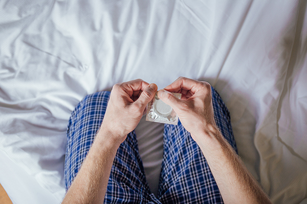 Uomo che adotta comportamenti sessuali sicuri per prevenire l’HIV, come l’uso del preservativo
