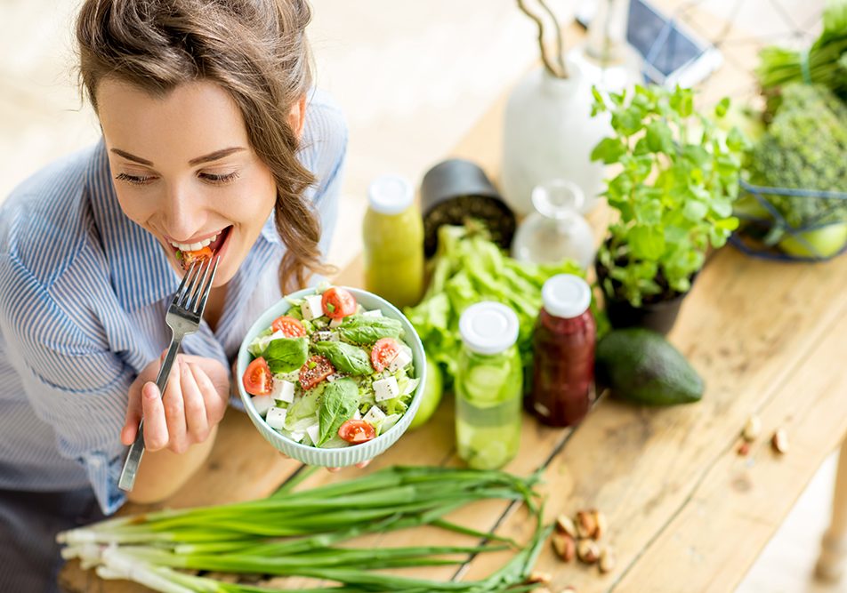 consumo-fibre-alimentari-insalata Donna che gusta un’inalata con lattuga, pomodori e tofu, assumendo una sana dose quotidiana di fibre alimentari