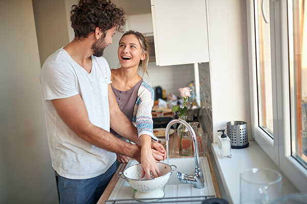 Giovane coppia che evita il contagio da scarlattina adottando misure precauzionali come il lavaggio delle mani