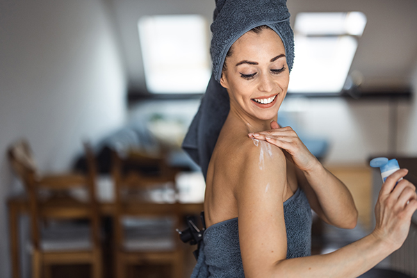 Donna che applica la permetrina in crema su tutto il corpo per la cura della scabbia