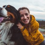 Donna che abbraccia il suo cane e che previene l’insorgenza di un tumore nel cane adottando uno stile di vita sano