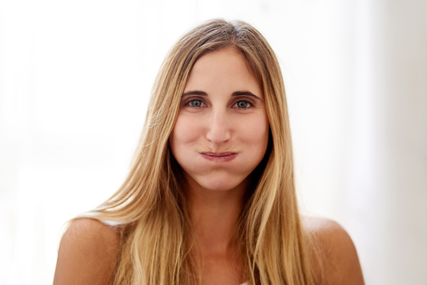 Donna che allevia il dolore delle placche in gola con rimedi naturali come i gargarismi con acqua salata