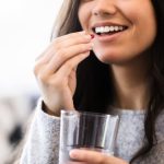 Giovane donna sorridente che assume amoxicilina