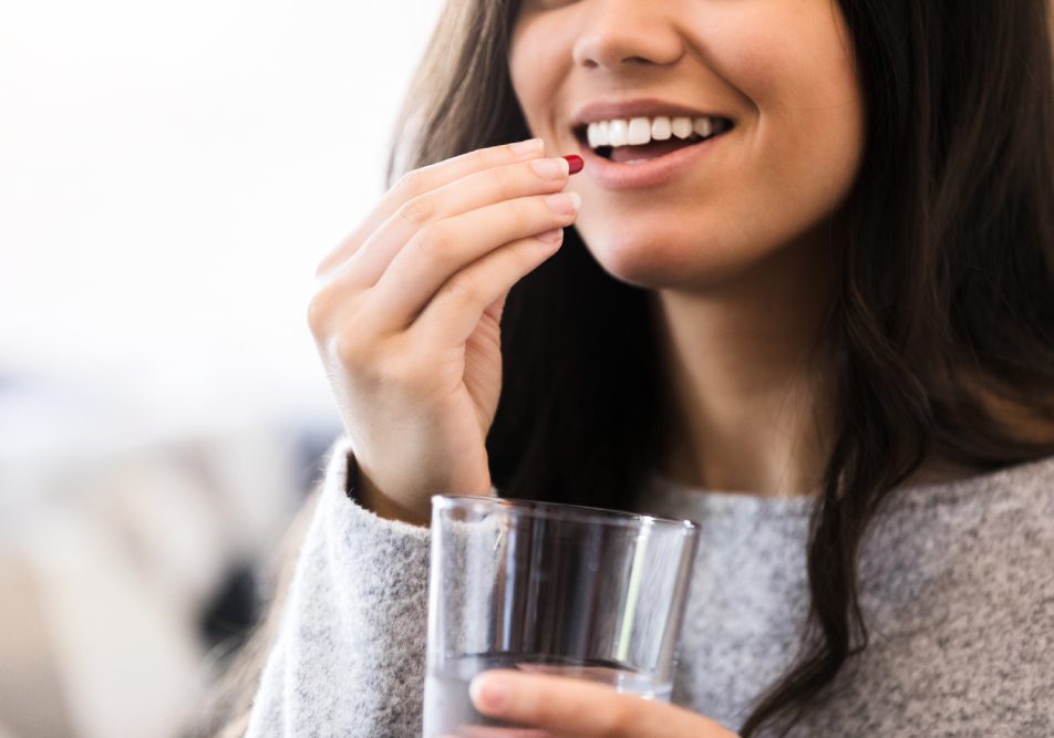 Giovane donna sorridente che assume amoxicilina