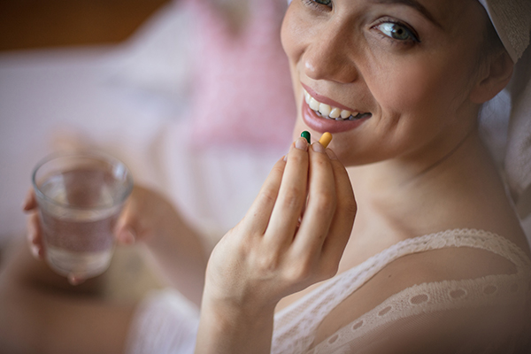 Donna che assume un antibiotico per la cura delle bollicine sul palato