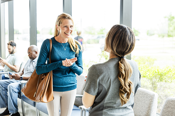 Donna con patologia rara come la fibrosi cistica che conversa nella sala d’attesa del reparto con l’infermiera