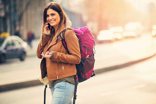 Donna che carica la schiena attraverso il peso di uno zaino, con possibile rischio di soffrire di tendinite alla spalla
