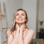 Donna con dolore alla spalla che si prende cura di sé, gratificata dopo avere compiuto esercizi di mobilità articolare