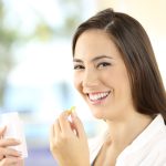 Giovane donna sorridente prende augmentin per infezione batterica