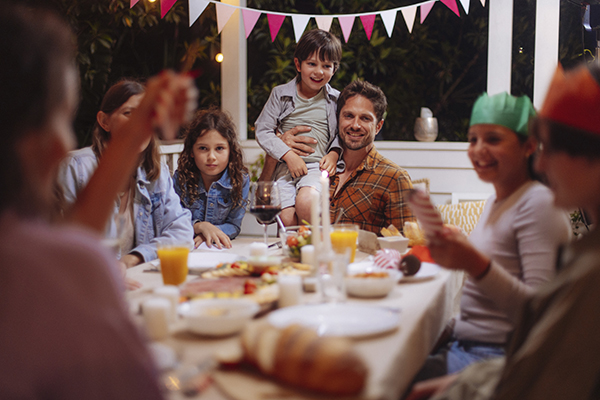 Famiglia intergenerazionale riunita a cena per festeggiamenti, a rischio di contagio da streptococco