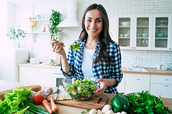 Donna che prepara un pasto ricco di fibre alimentari da portare in tavola