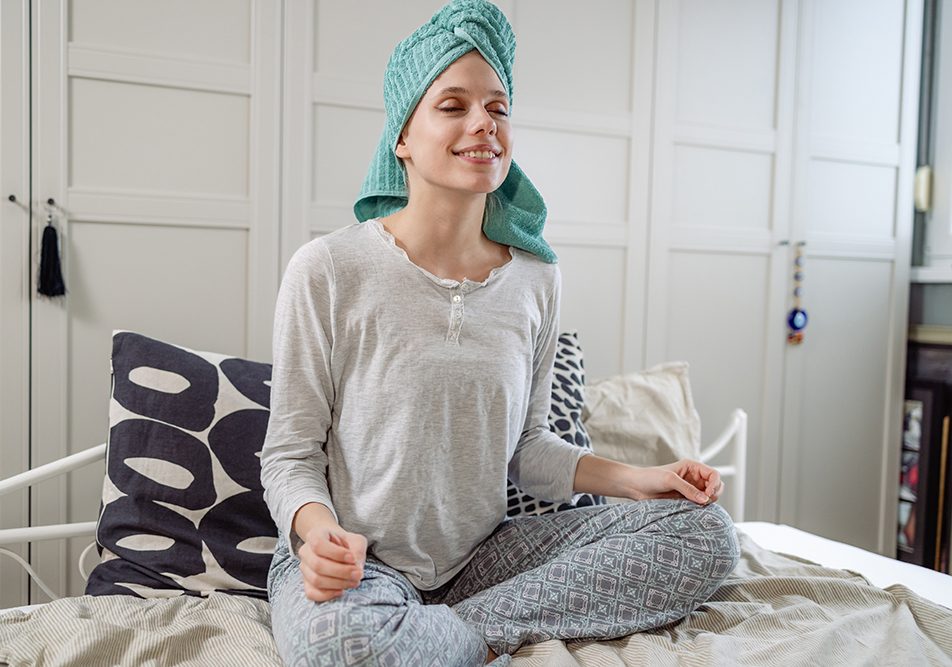 Giovane donna che si prende cura di sé nella sua camera da letto mentre è in attesa di ricevere il trapianto di midollo osseo