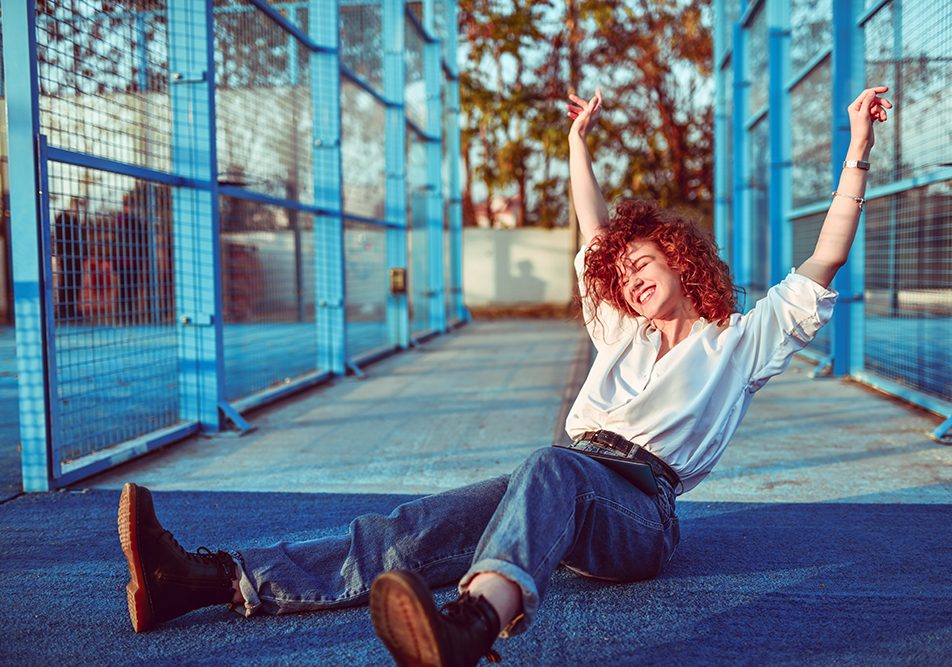 Giovane donna allegra al parco dopo avere ricevuto invito a sottoporsi al suo primo Pap test