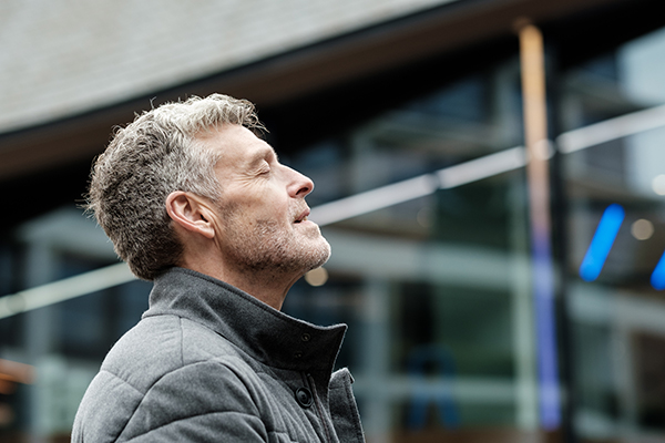 Uomo tra le vie cittadine esposto all’inquinamento atmosferico, un fattore di rischio del tumore ai polmoni