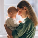 Giovane madre in un momento di amore e maternità insieme al suo neonato