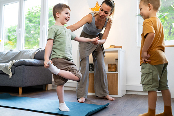 Madre che insegna attività fisica ai bambini come forma di prevenzione dallo streptococco