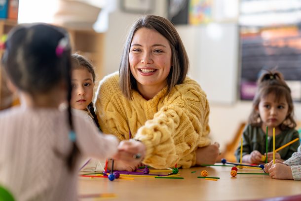 maestra-con-bambini-incubazione-streptococco Maestra sorridente insieme ai suoi piccoli alunni, durante il periodo di incubazione dello streptococco