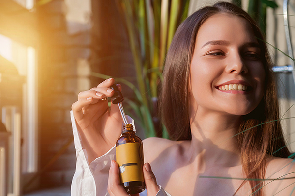 Giovane donna che applica una lozione di olio di neem per debellare la scabbia