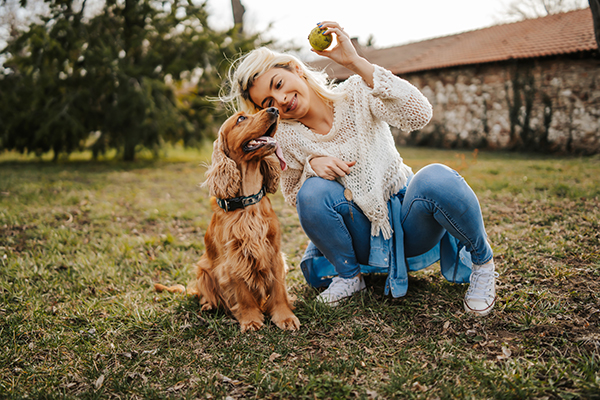 Padrona che gioca al parco insieme al cane gioioso, per stimolare il naturale consumo delle sue unghie