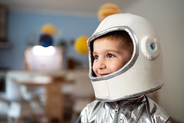 Bambino che, mentre gioca all’astronauta, copre bocca e naso mentre starnutisce, in quanto lo streptococco è contagioso