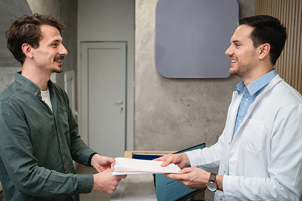 Uomo con malattia cronica come la sclerosi multipla che riceve dal suo medico il referto di un esame diagnostico