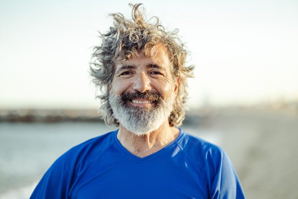 uomo-maturo-prevenzione-streptococco-con-attivita-fisica Uomo maturo sorridente dopo una camminata sulla spiaggia che previene lo streptococco grazie all’attività fisica all’aria aperta