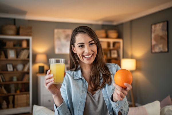 Giovane donna beve spremuta ricca di vitamina C