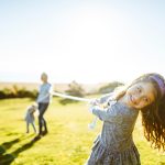 Bambina che gioca insieme alla sua famiglia al parco, conducendo uno stile di vita sano e attivo come forma di prevenzione contro lo streptococco